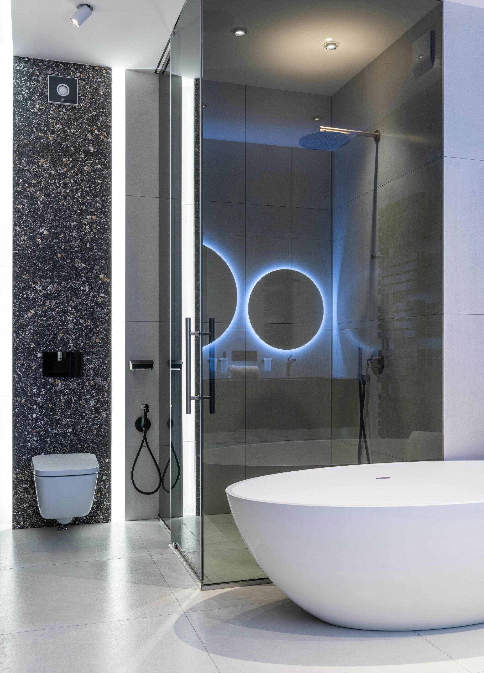 Sleek modern bathroom featuring a freestanding tub and illuminated shower area.